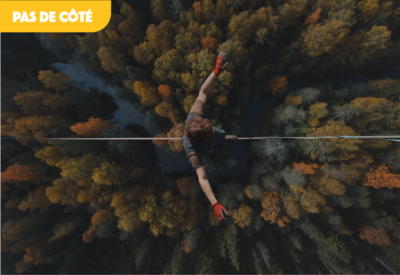Un funambule marche sur un fil au dessus d'une forêt