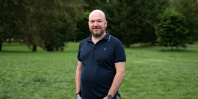 Portrait de Guillaume Limousin en extérieur, debout dans un parc avec des arbres en arrière-plan.